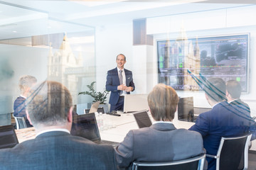 Businessman giving a talk in conference room. Business executive delivering presentation to business partners during business meeting. Corporate business concept.