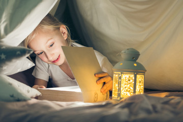 Girl reading book in tent © Photographee.eu