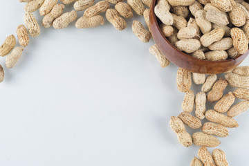 Peanuts in wooden bowl on isolated white background