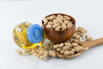 Concept oil of peanut with peanuts scattered on isolated with background
