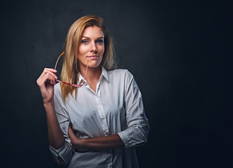 Fototapeta premium Blond female dressed in a white shirt and red eyeglasses.
