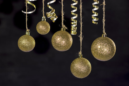 Image of christmas festive tree gold ball decoration in front of black background