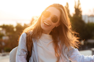 Close up picture of smiling brunette woman in sunglasses