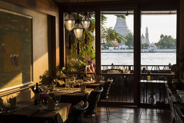 Luxury restaurant overlooking Wat Arun at sunset time, Bangkok, Thailand