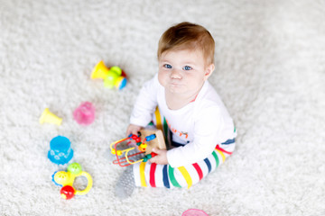 Fototapeta na wymiar Adorable baby girl playing with educational toys in nursery