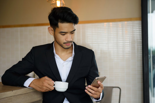 businessman using smartphone during coffee time