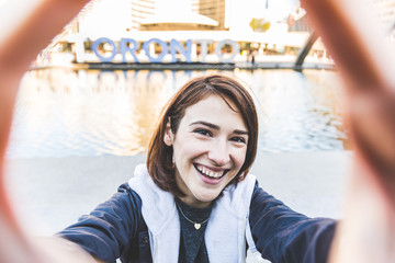 Happy smiling girl taking a selfie in Toronto