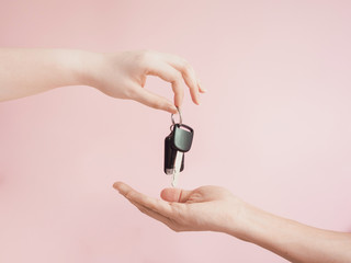 asian woman give her  car key to new car owner by beauty finger and hand with pink pastel background
