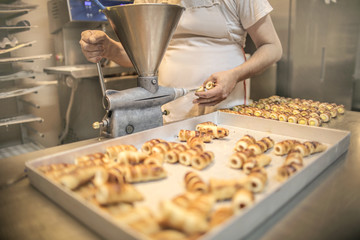 Chef filling cannoli with cream