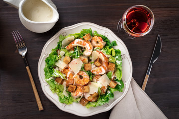 Shrimp Caesar salad with sauce and rose wine