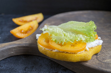 Bun with lettuce and soft cheese.