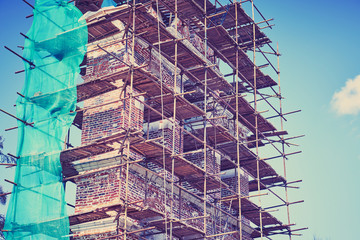 Restoration of old ruins on the background of blue sky. Toned.
