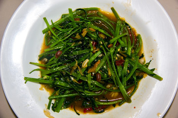 stir-fried morning glory thai food style on white dish