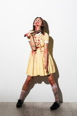 Full length portrait of mad zombie woman bleading
