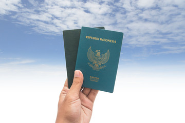travel concept - hand with passport and cloud background. Indonesia passport.