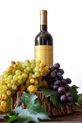 Fototapeta na wymiar Bottle wine of bunch white and red grape on wooden background.