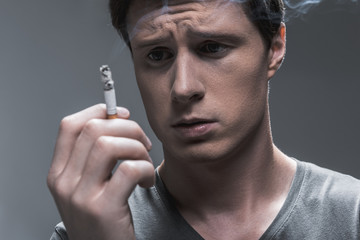 Young man expressing hesitation about smoking