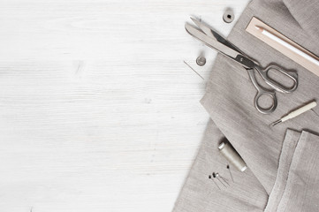 Linen fabric and sewing tools on the white wooden table