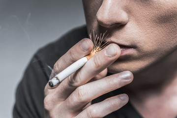 Guy inhaling smoke of harmful cigar