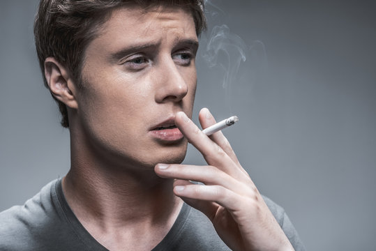 Guy inhaling nicotine from cigarette