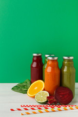 Assortment of detox smoothies in glass bottles on wall background.