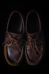 brown leather topsides on a black background