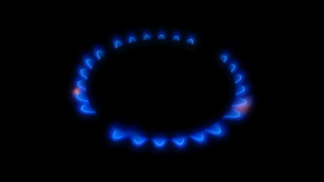 Gas stove blue flame turning on and off in the dark - Close up 2