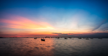 Fototapeta premium silhouette fishing boats on the sea during twilight sky