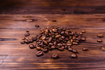 Pile of the roasted coffee beans on wooden table