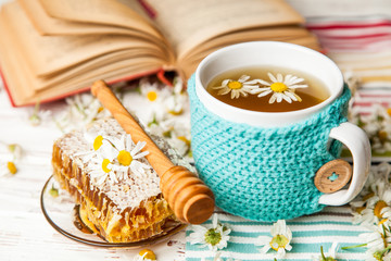 Honeycomb and chamomile tea on white