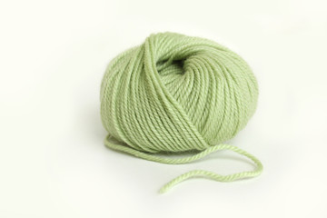 a skein of green wool yarn on white background