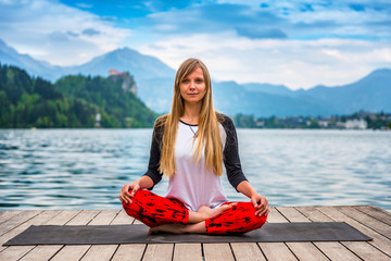 Woman doing yoga by the lake