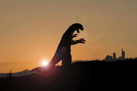 Silhouette eines Godzilla-artigen Monsters auf dem Weg in die Stadt