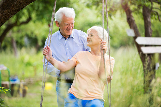 Senior Couple Outdoors With Tree Swing
