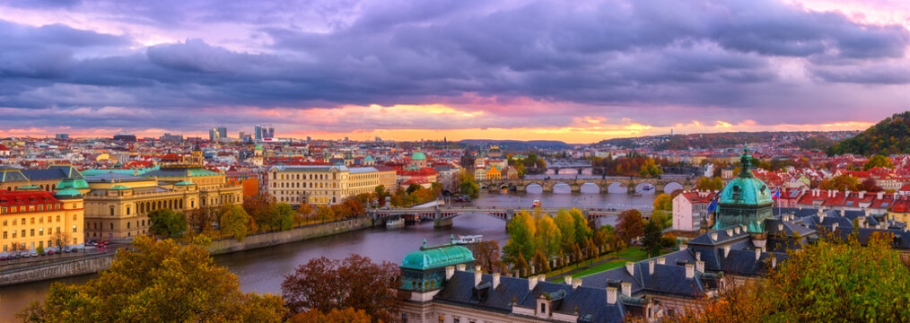 Sunset in Prague panorama, view to the historical bridges, old town and Vltava river from popular view point in the Letna park, autumn landscape in sunset light with amazing cloudy sky, Czech Republic