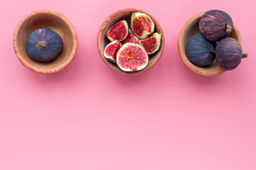 Fresh blue figs in bowls on pink background top view copyspace