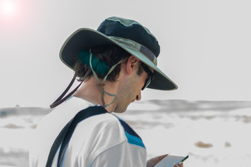 Young man with hat holding mobile smart phone.