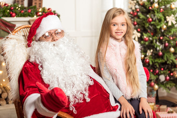 Happy child celebrating Christmas with Santa Claus