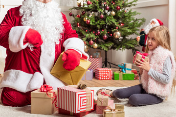 Obraz na płótnie Canvas Curious female kid getting Christmas presents