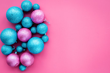 Christmas toys. Blue and pink balls on pink background top view