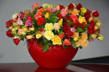 Großer gelb roter Blumenstrauss in einer roten Vase