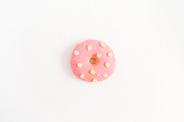 One pink donut on white background. Flat lay, top view minimal concept.