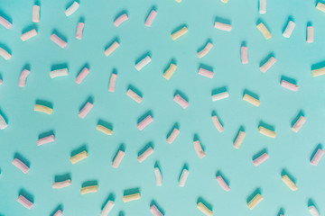 Colorful marshmallow pattern on pastel blue background. Flat lay, top view minimal concept.