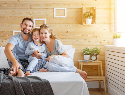 happy family mother, father and child   laughs in bed