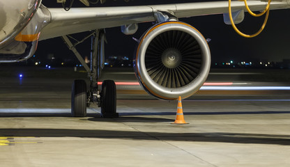 Engine and chassis of passenger jet plane in the night. Front view. Aircraft air intake and fan...