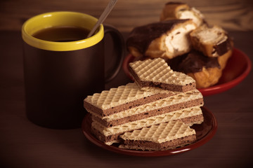 Coffee, waffles and cakes on a wooden background