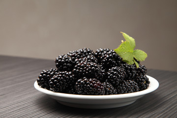 blackberry in a plate/ blackberry in a plate on the background of a table