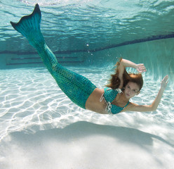 Beautiful young women in a swimsuit, or mermaids tail above and below the water.