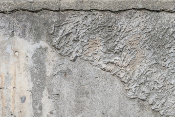 old chipped plaster on the concrete wall, grey texture, background