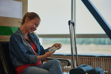 Young beautiful woman waiting for the boarding time in the airport.